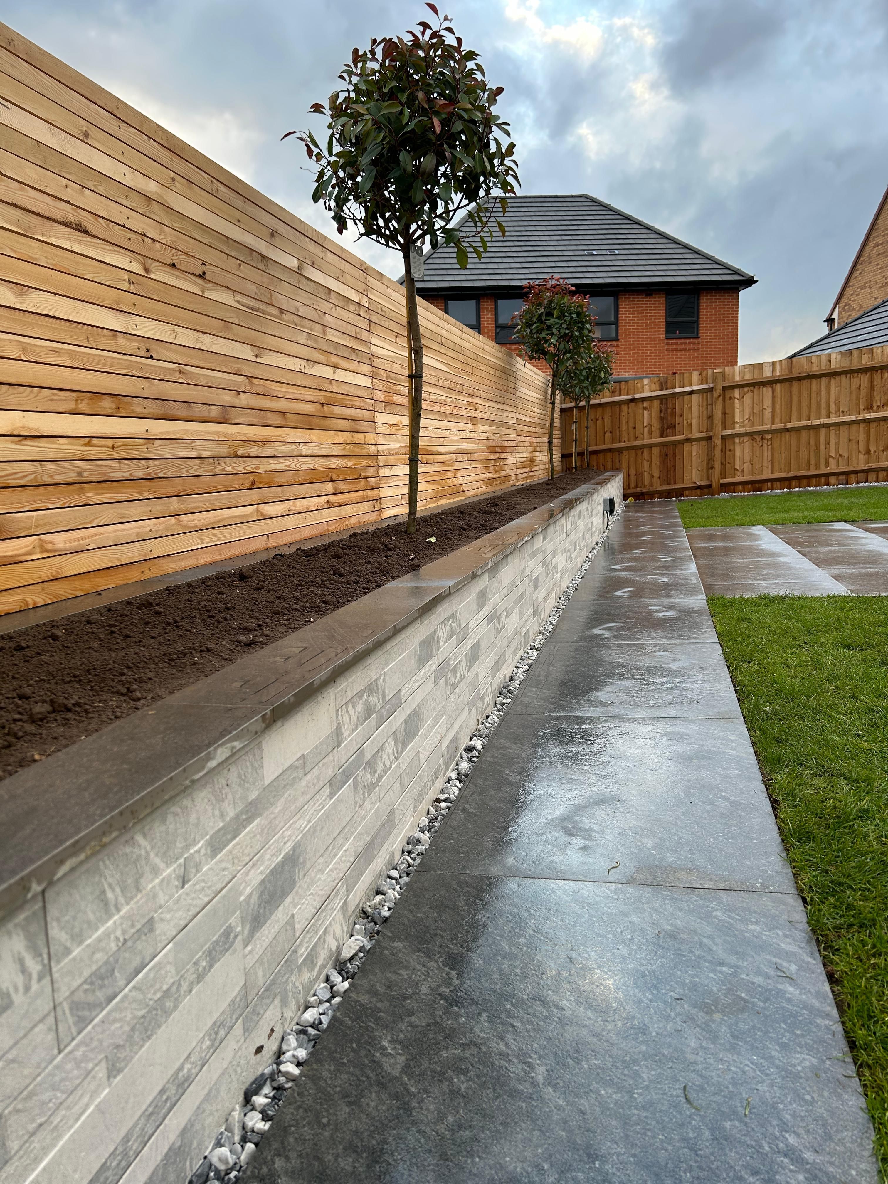 Timber garden boundary, planting bed, stone-edged path and lawn in an original Progreen project photograph