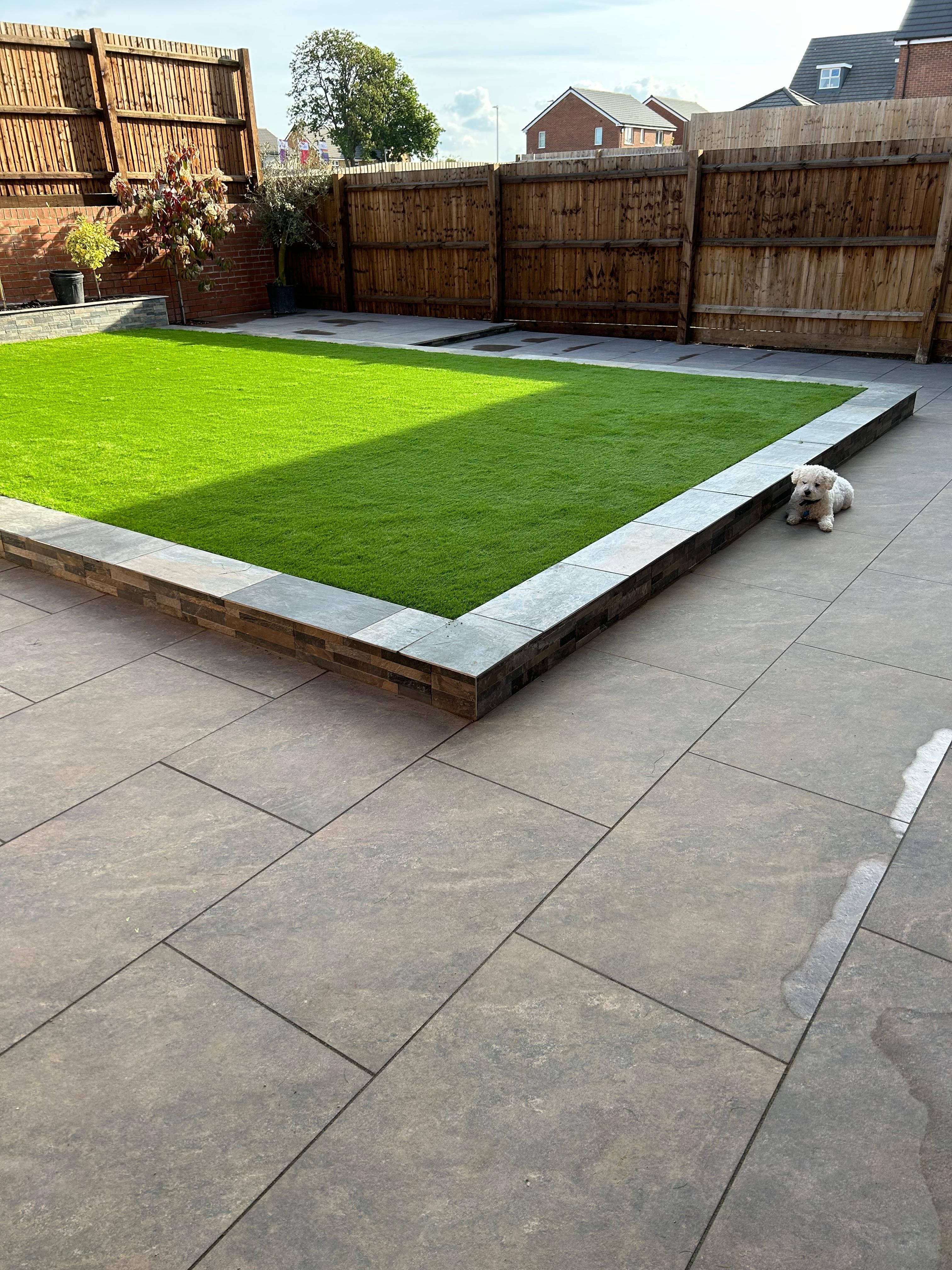 Lawn and raised landscaping area showing a combination of greenery and defined edges
