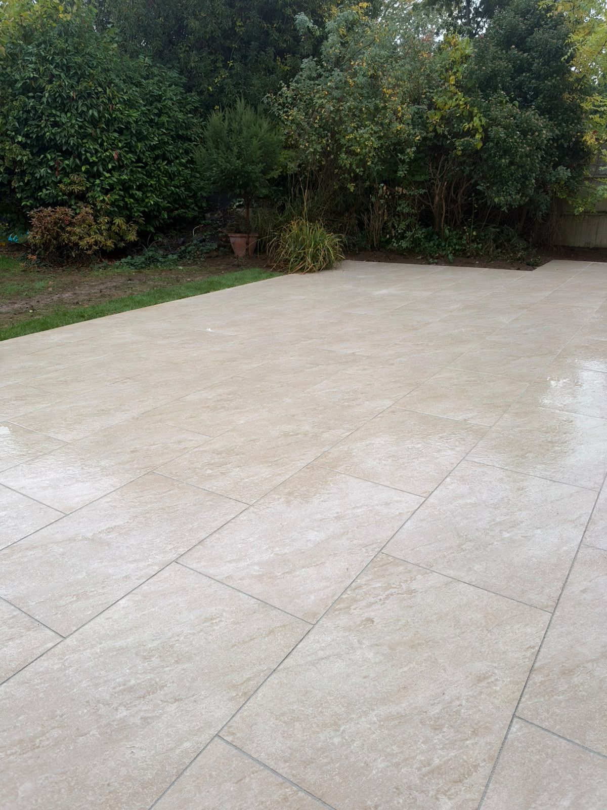 Paved terrace beside established planting and fencing at a St Albans house