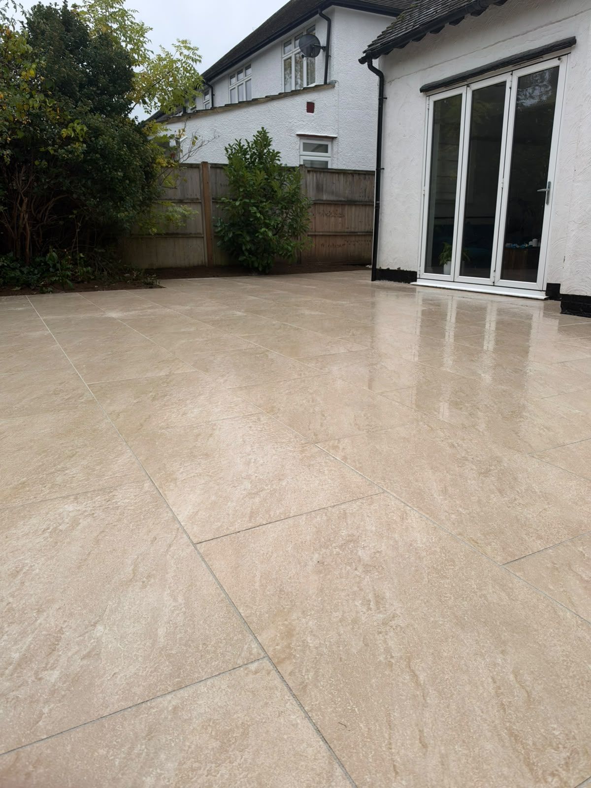 Large light-coloured paved patio outside a white house in St Albans