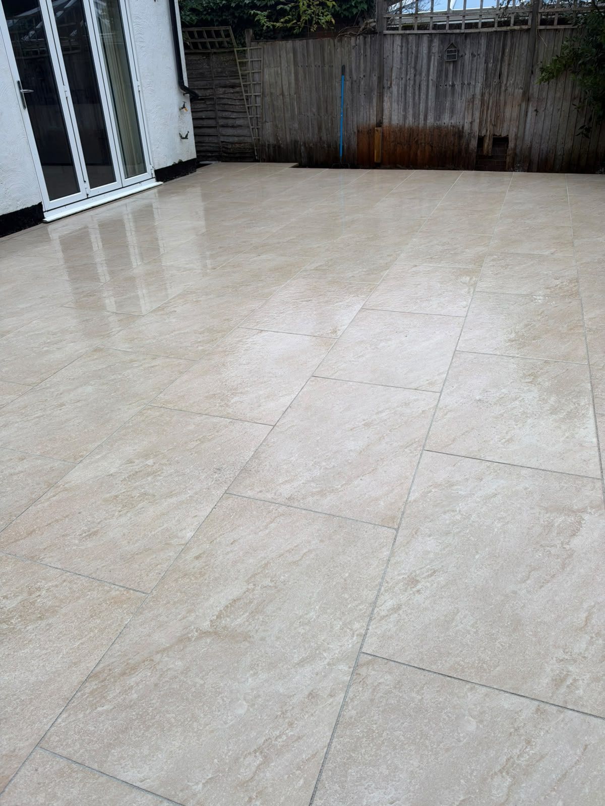 Second view of light patio paving beside house doors and mature plants in St Albans